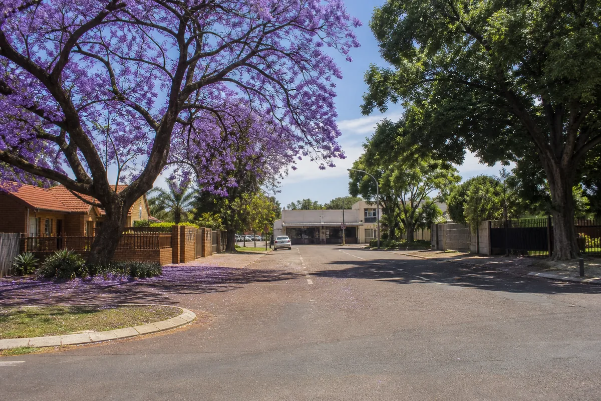 Residential streets with mature trees and local shops in Claremont, within HoneySucker's Pretoria West septic service coverage